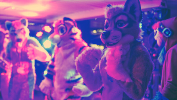 Fursuiters in a boat interior lit by colorful lights